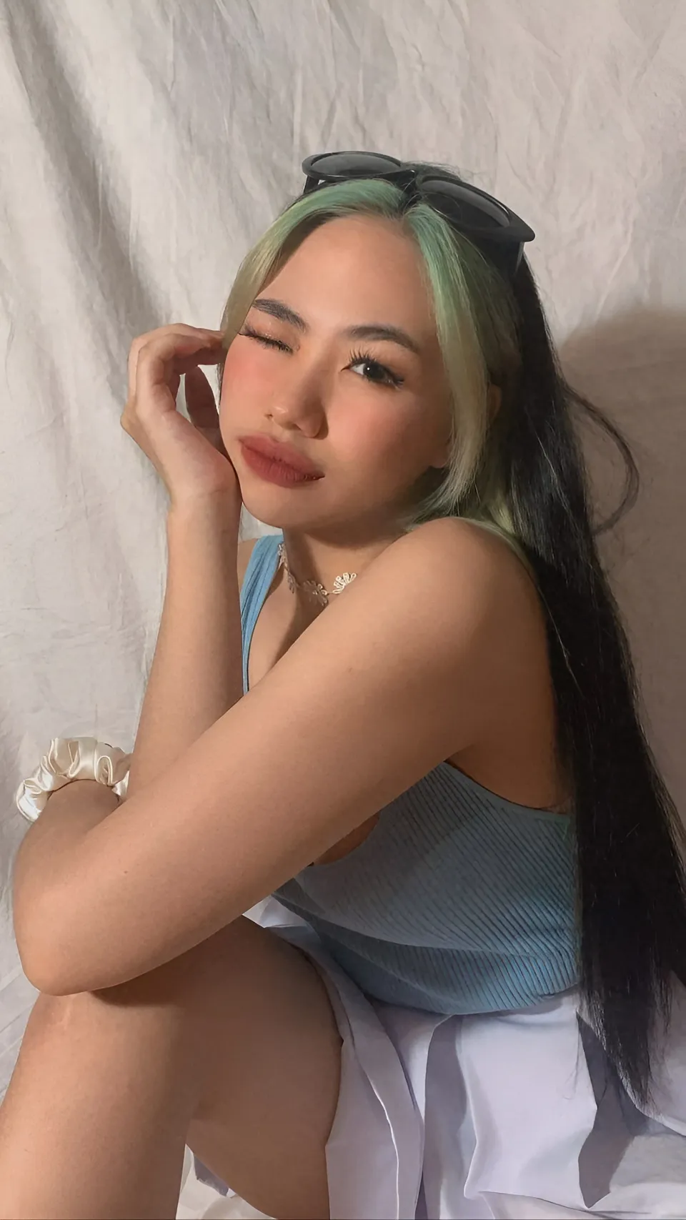 Kylene Santos with green hair wearing blue top and white skirt