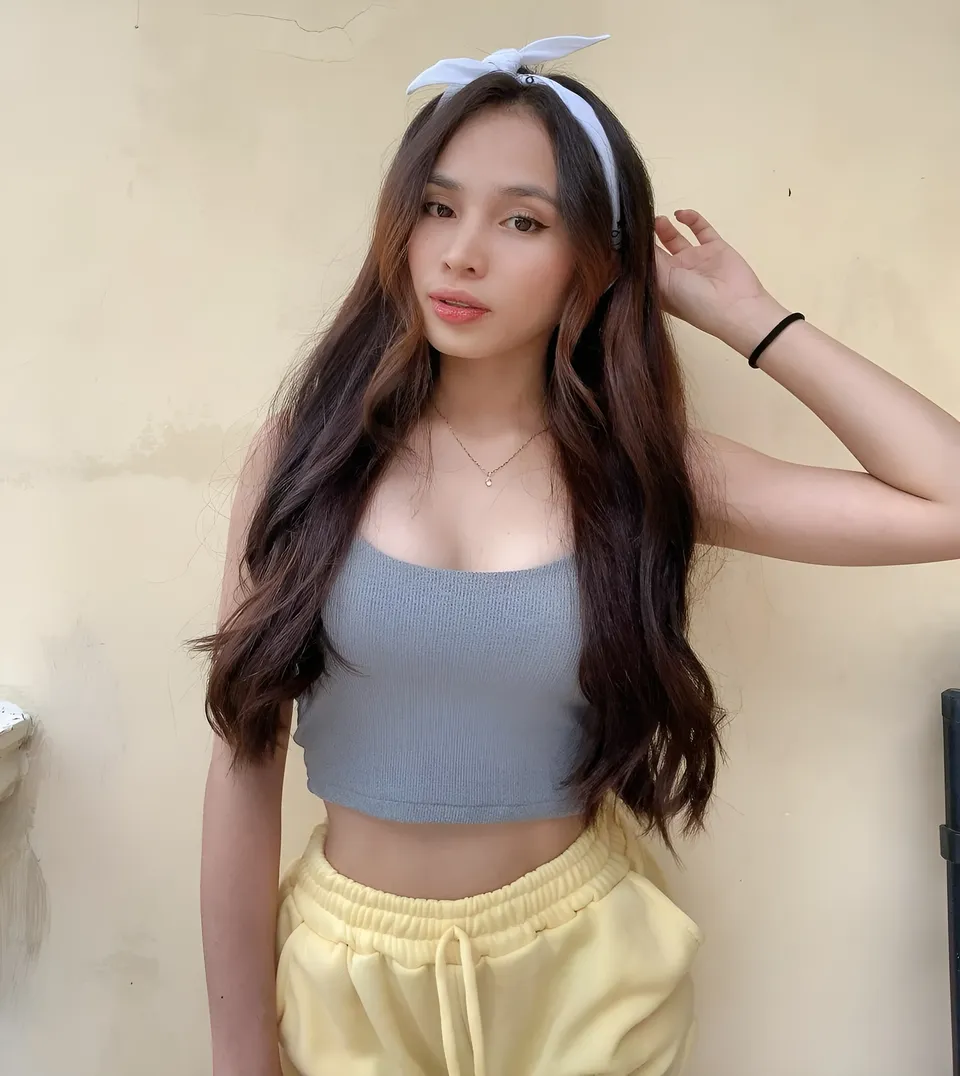 Lhyn Ampong wearing gray crop top and yellow pants with headband
