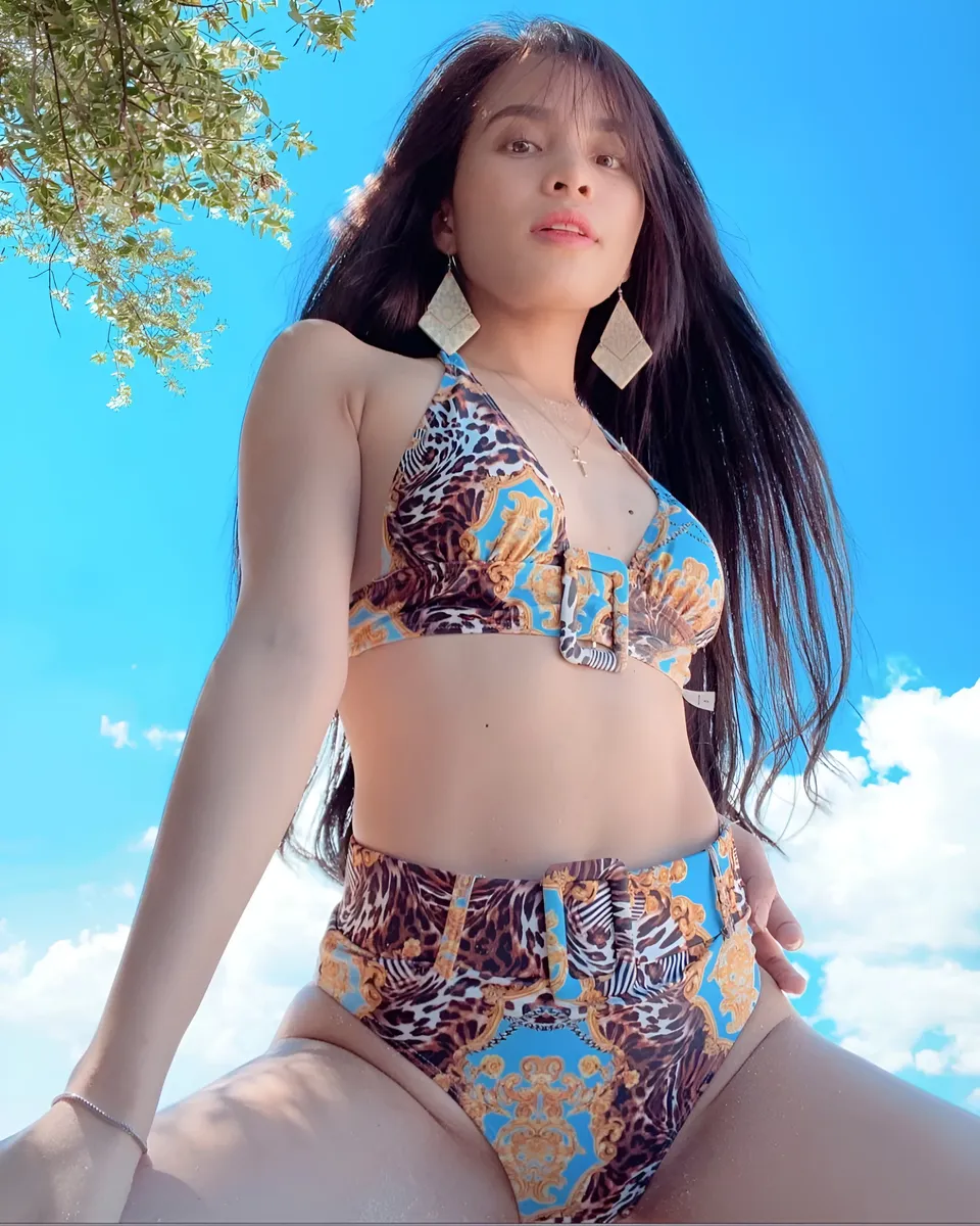 Lhyn Ampong in patterned bikini seated outdoors under tree