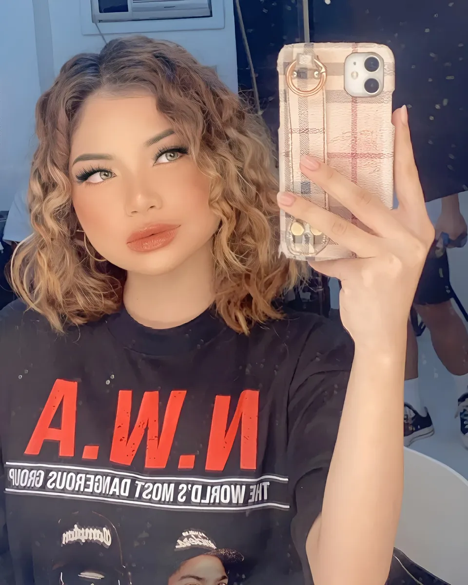 Lia Laureola taking selfie with phone in plaid case