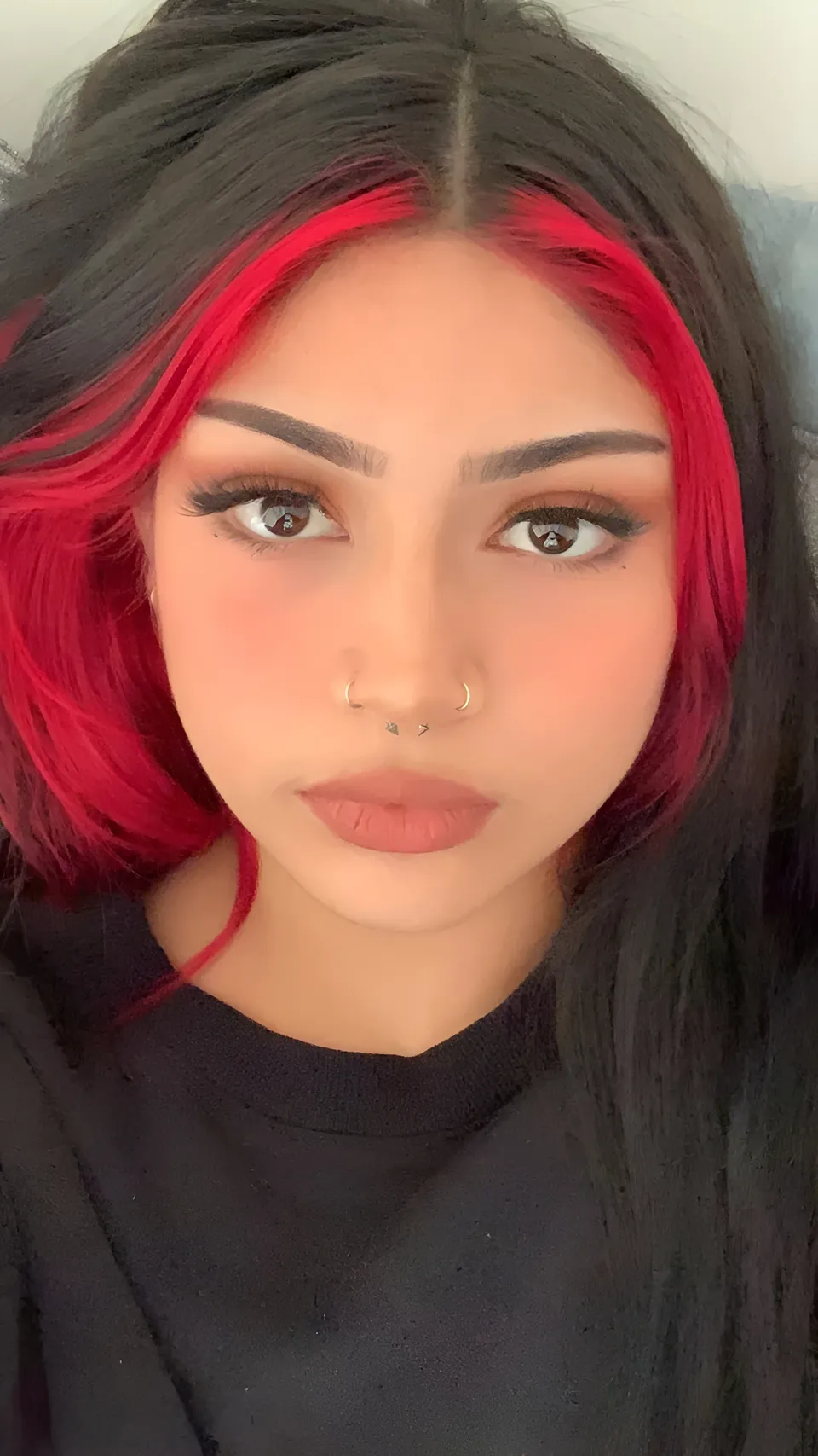 Lia Mae Vumbaca with red and black hair wearing black top