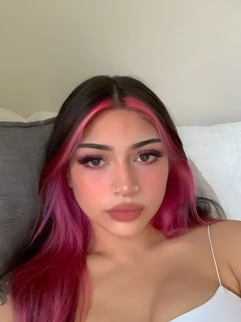 Lia Mae Vumbaca with pink hair and makeup in close-up portrait