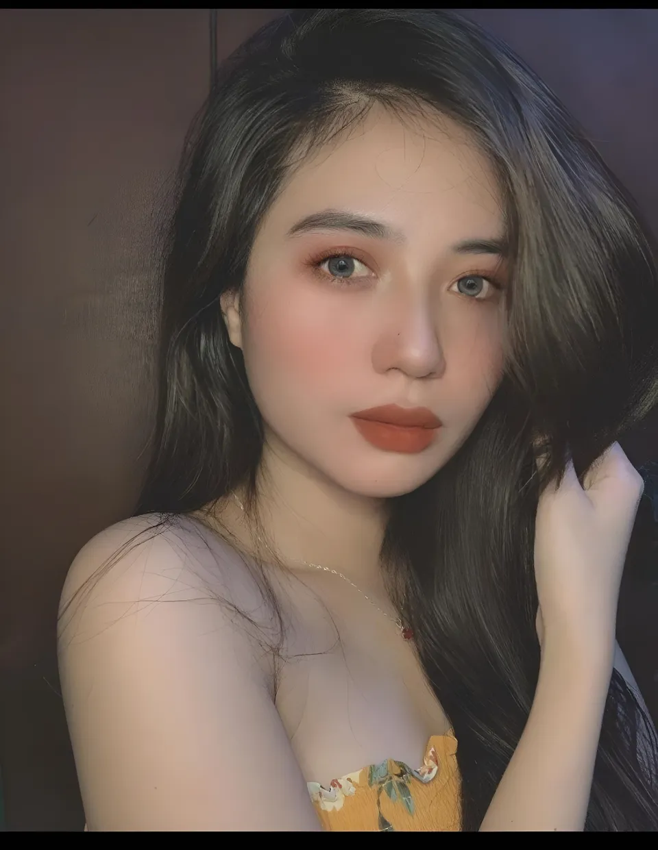 Mae Roxas in floral top with hand near face