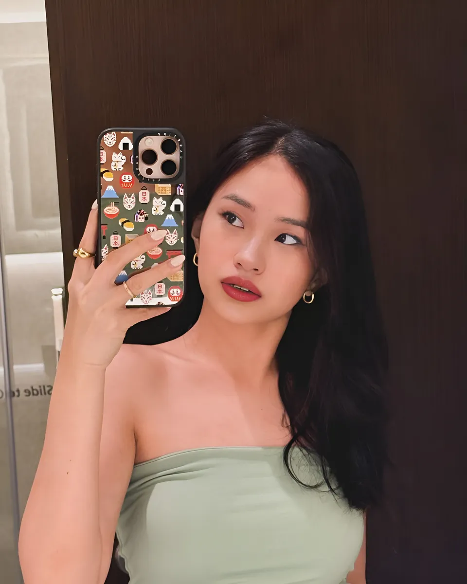 Maeve Linden holds phone with patterned case while taking mirror selfie