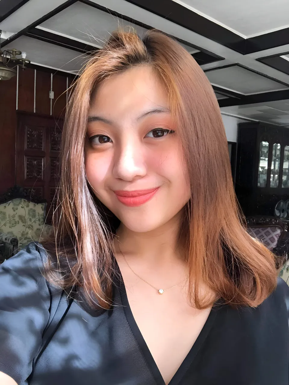 Mariah Protacio in black top with shoulder-length hair smiling at camera