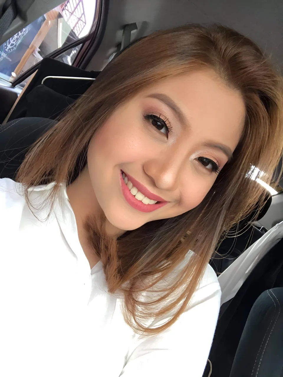 Mariah Protacio smiling in car wearing white top