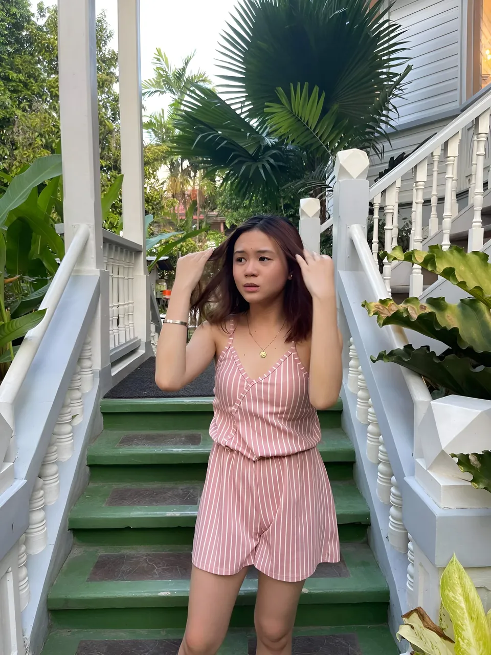 Marj Teves in pink striped romper standing on green stairs