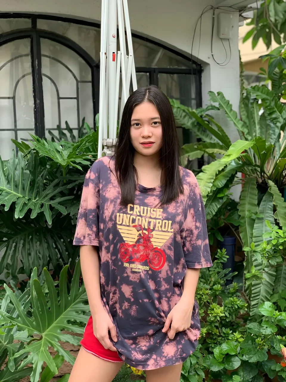 Marries Cabral wearing tie-dye t-shirt and red shorts outdoors