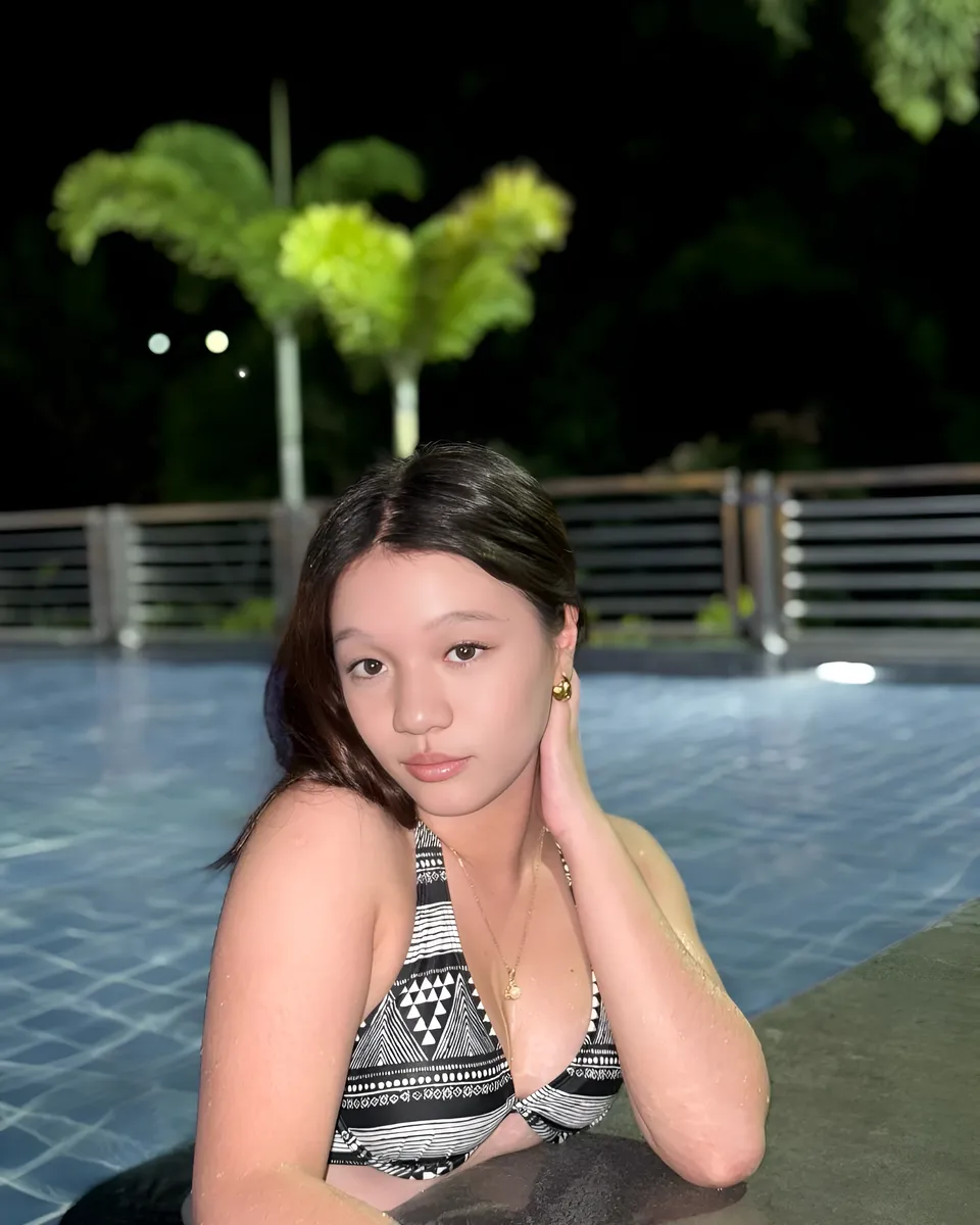 Maryshel Monroe in patterned top seated by pool at night