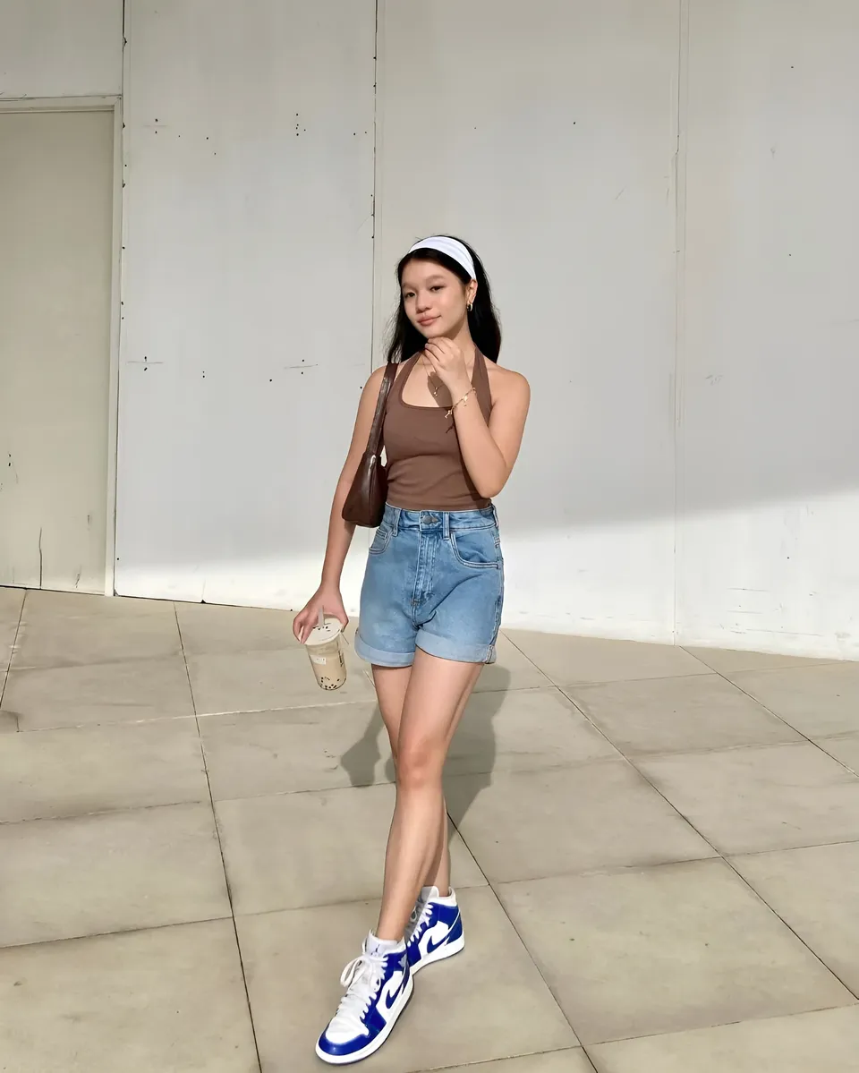 Maryshel Monroe standing outdoors holding drink and bag