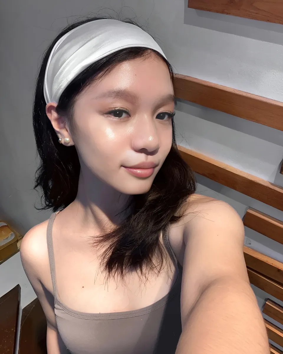 Maryshel Monroe wearing gray top and white headband in indoor setting