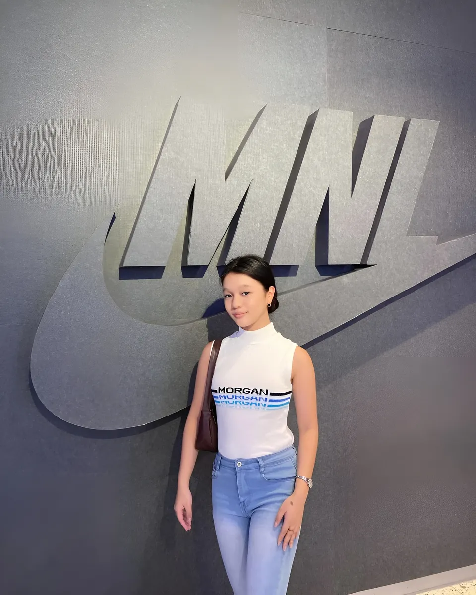 Maryshel Monroe standing in front of large logo wall
