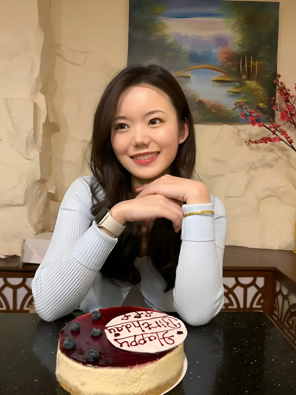 Maya Beaumont in white top smiles beside birthday cake