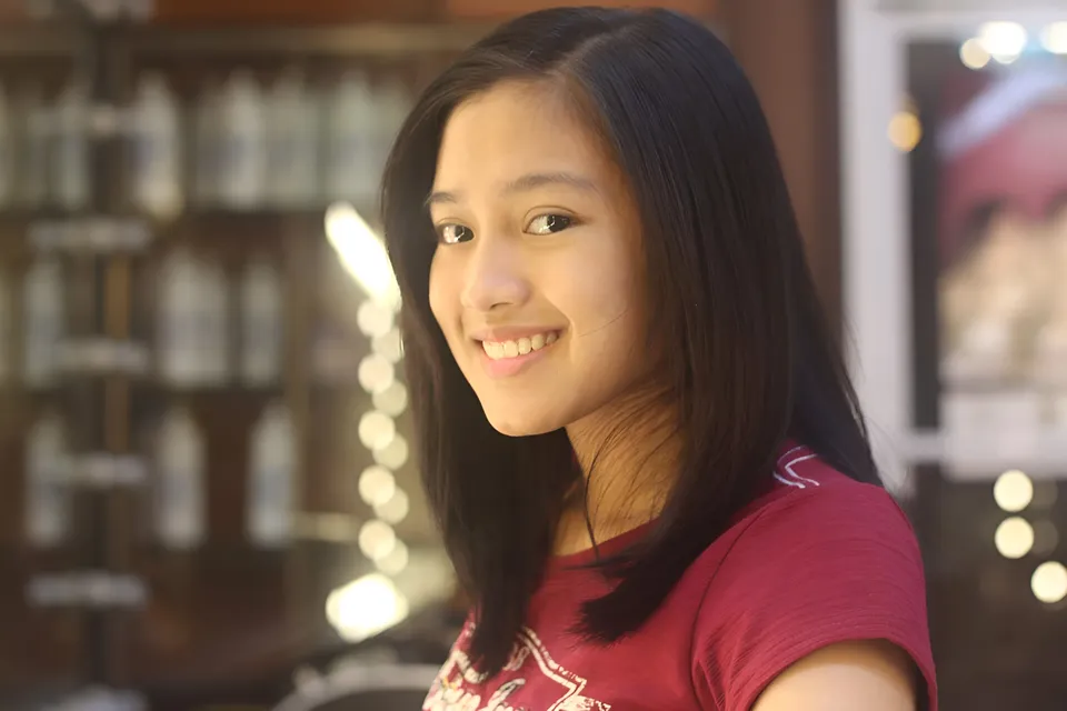 Mikaela Baldos in red top smiling at camera