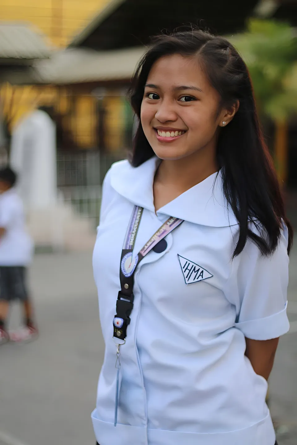Mikaela Baldos wearing a white collared shirt smiles outdoors