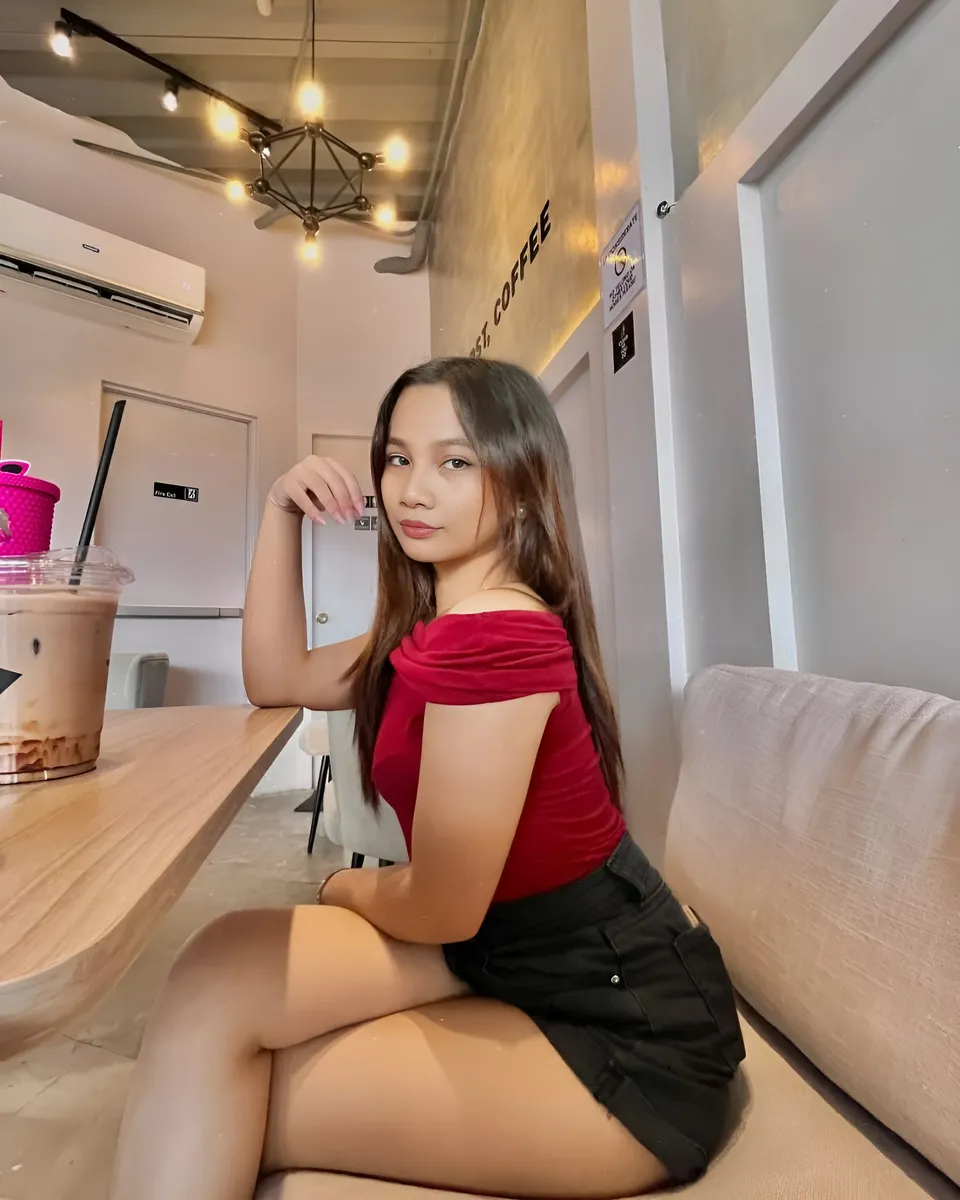 Mikay Alexis in red top seated at coffee shop table