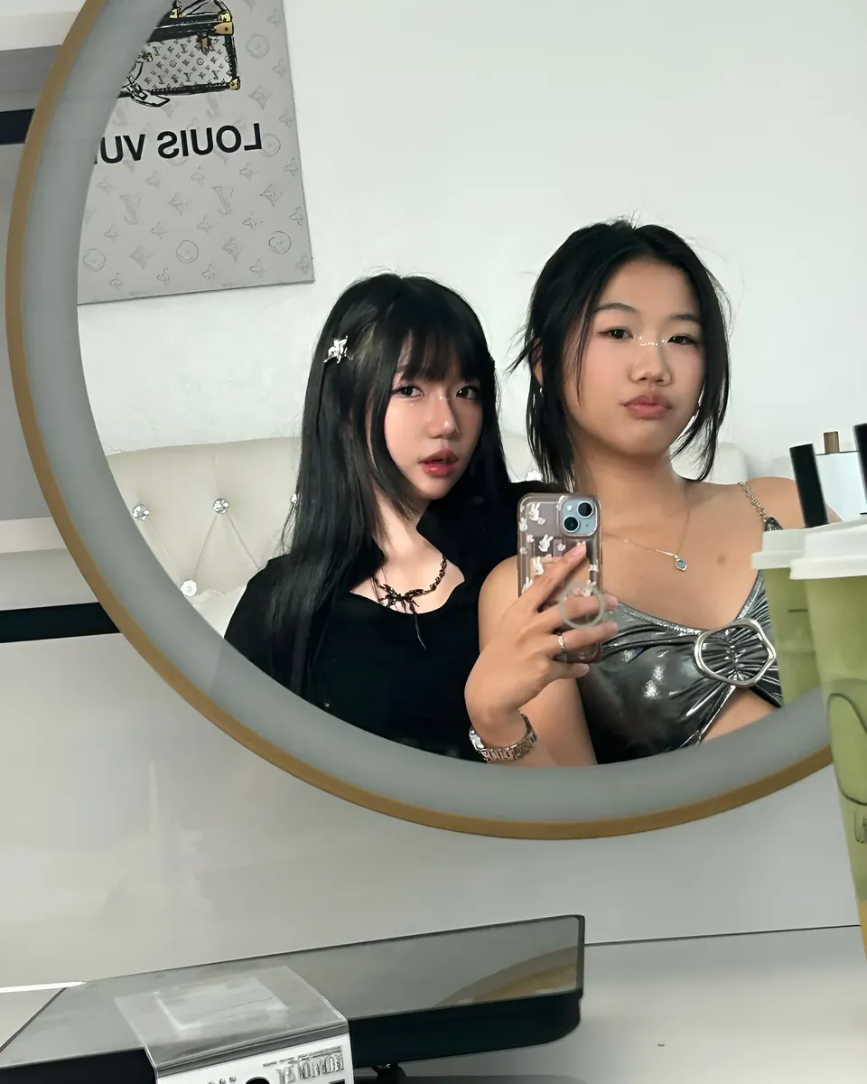 Mina Hartley — Two people taking mirror selfie with phones and drinks