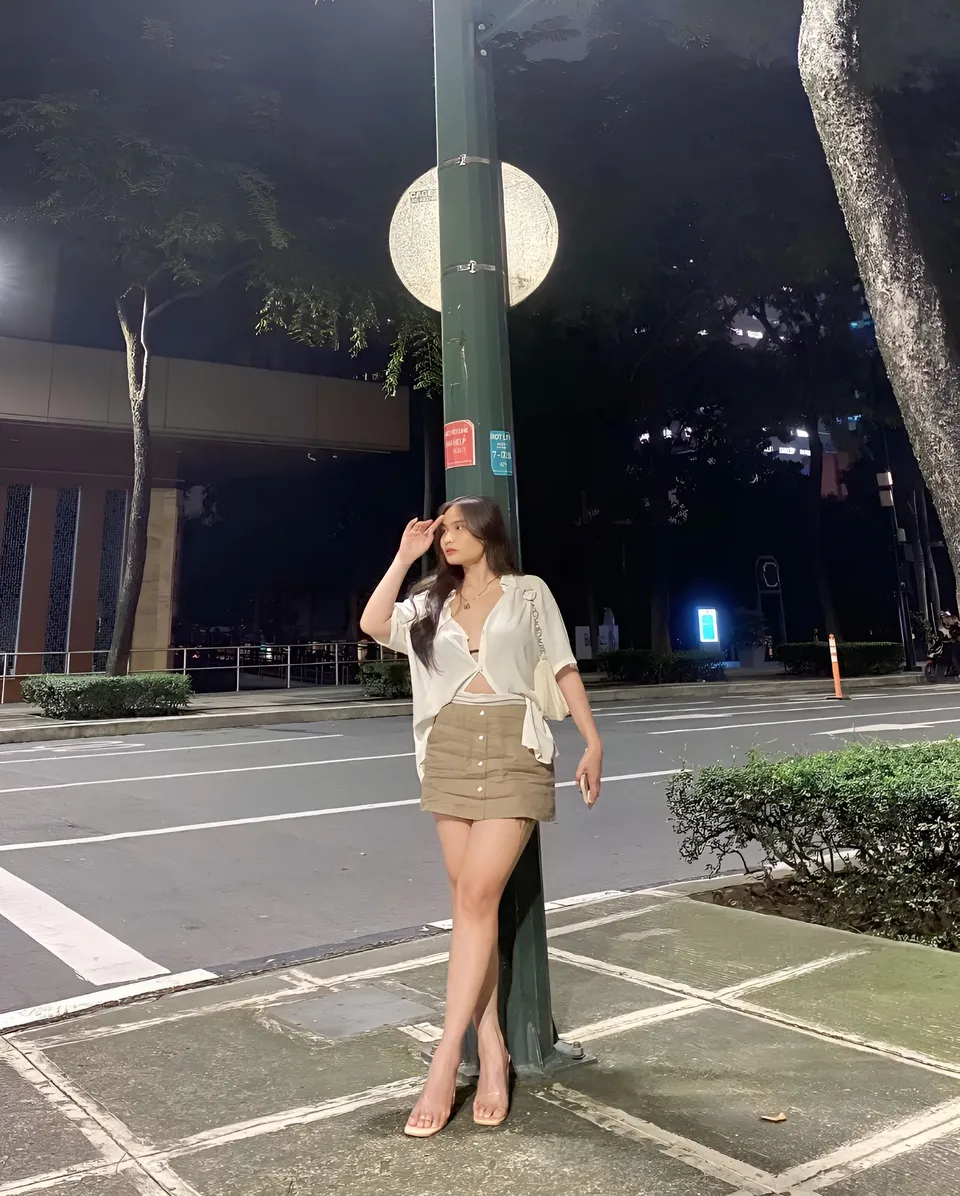 Mira Collins standing beside street lamp at night