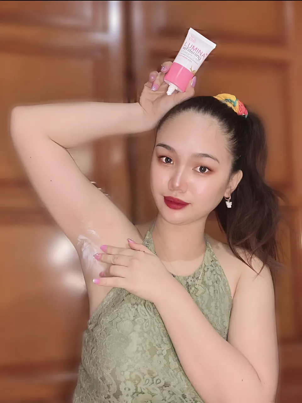 Nica Gueverra applying cream to underarm while holding product tube