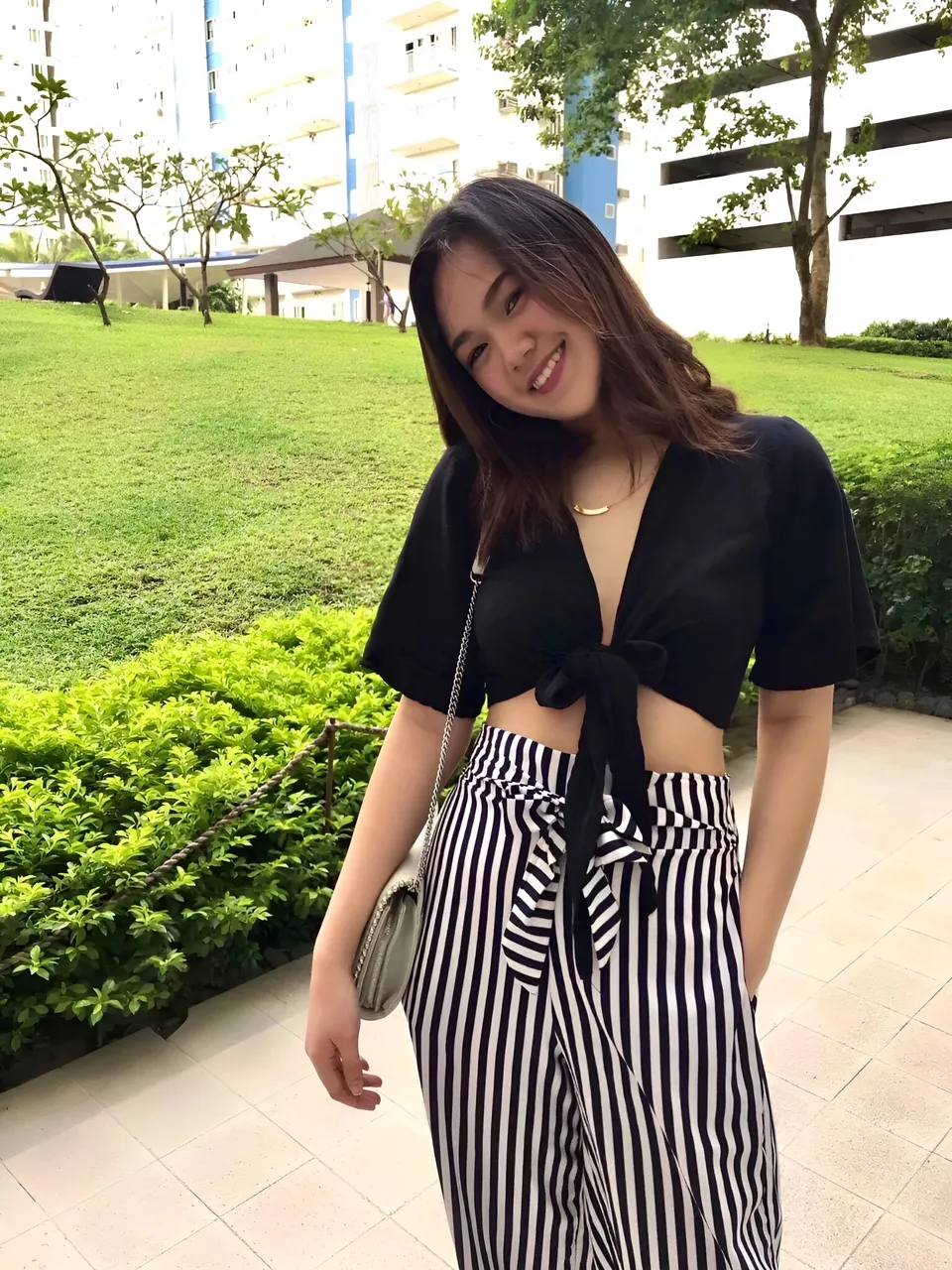 Pia Gonzales in black top and striped pants standing outdoors