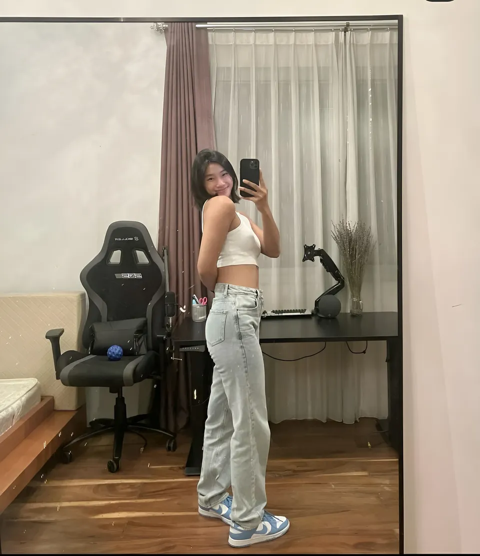 Pia Idelfonso taking mirror selfie in room with gaming chair and desk
