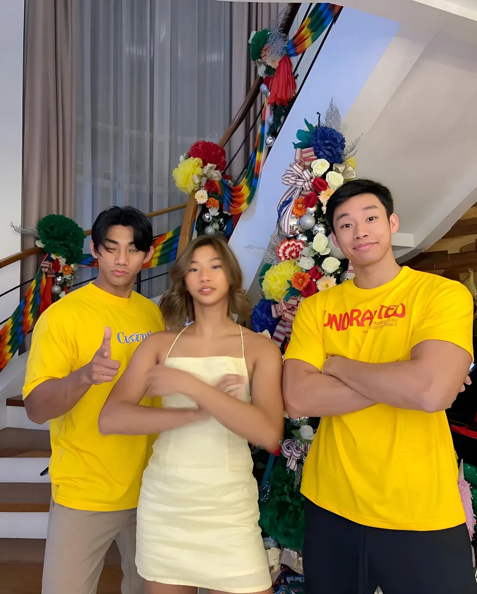 Pia Idelfonso — Three people in yellow shirts standing near staircase with decorations
