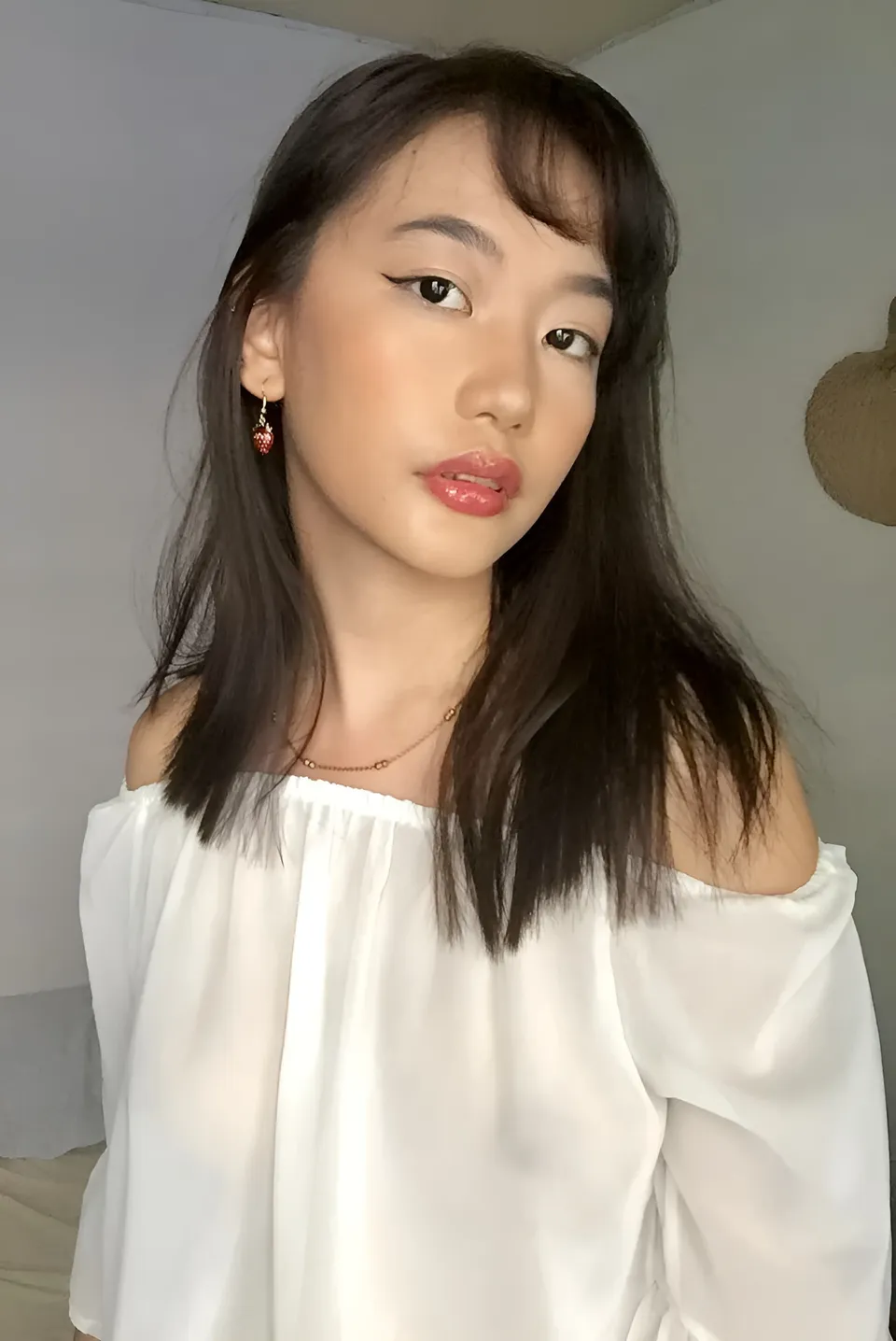 Ramoana Sinclair wearing white off-shoulder top in indoor setting