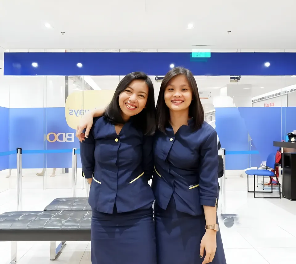 Roxanne Ellery — Two people in navy uniforms posing together indoors