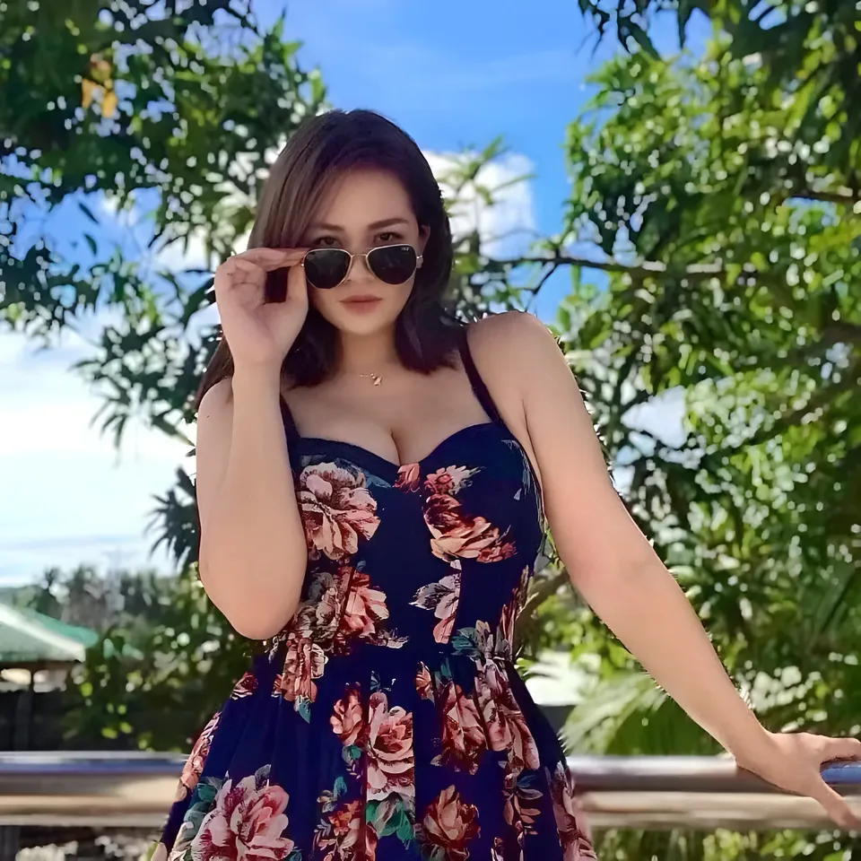 Roxell Tann in floral dress wearing sunglasses outdoors