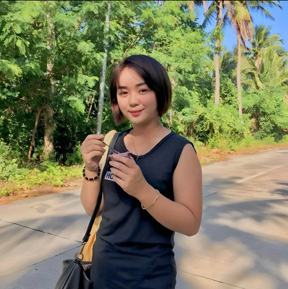 Sakura Keyema in black top holding spoon and cup outdoors