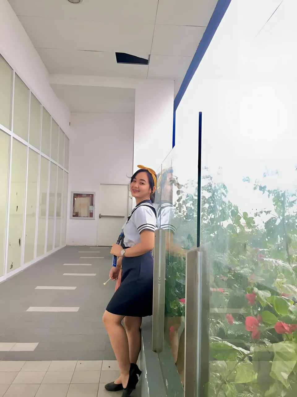 Sakura Keyema in uniform leaning against glass barrier