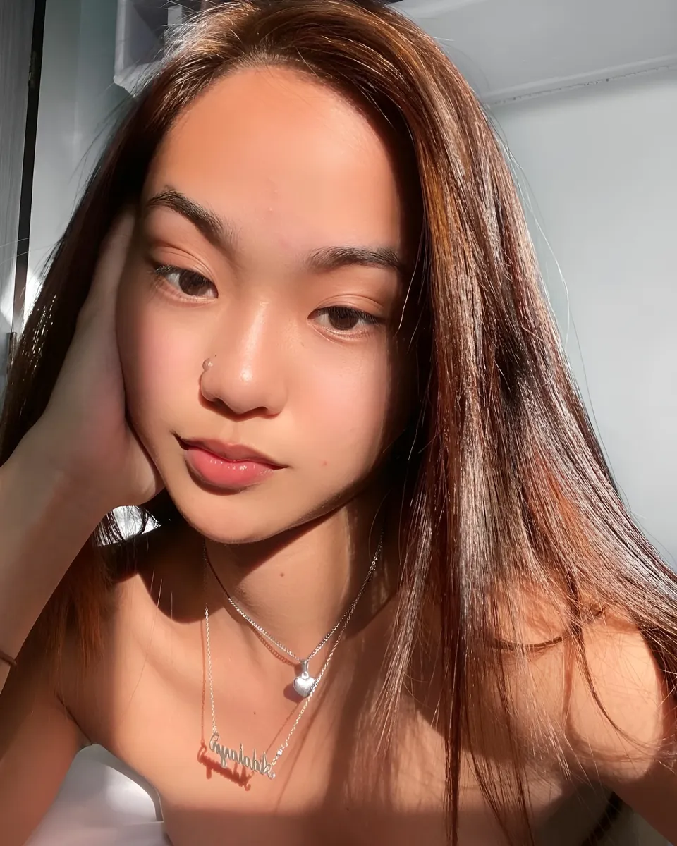 Shaira Adalyn with long hair and necklaces in sunlight