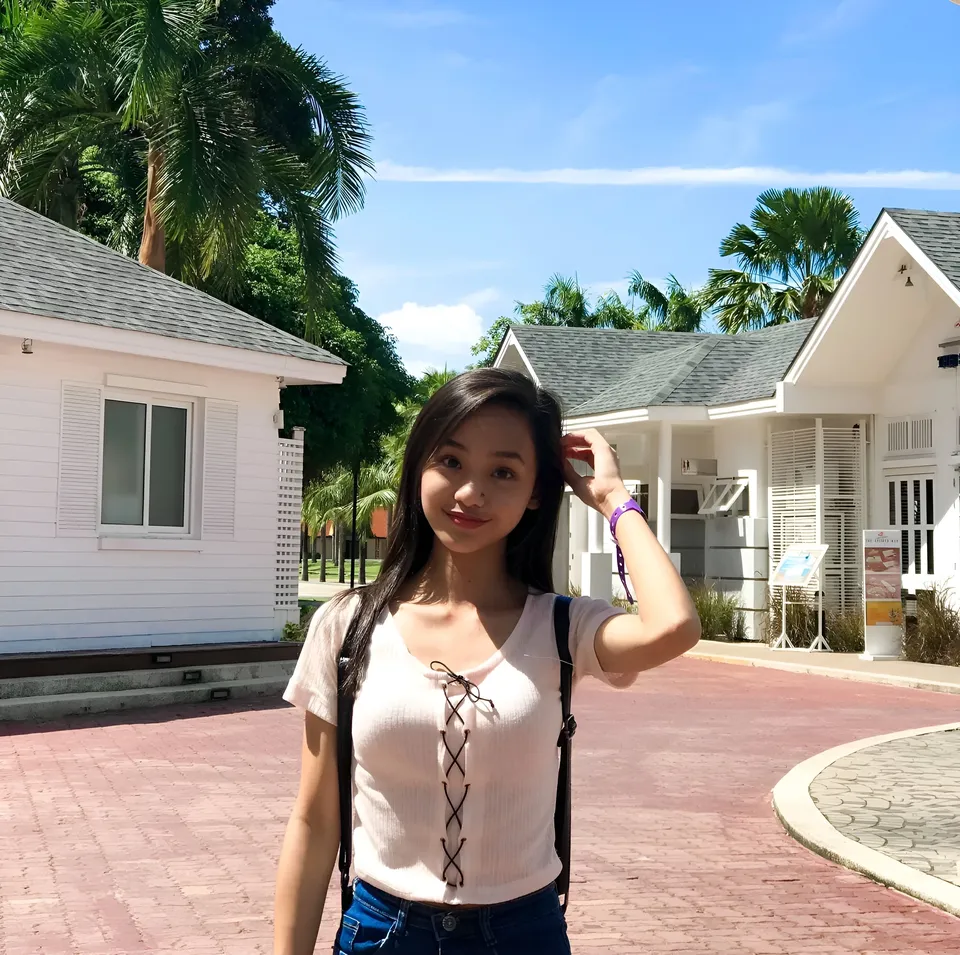 Shaira Adalyn standing outdoors near white buildings with palm trees