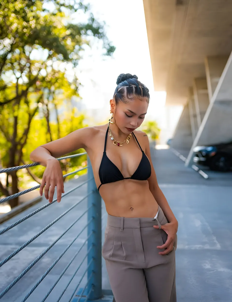 Sheeny Roswell in black top and grey pants leans against railing outdoors