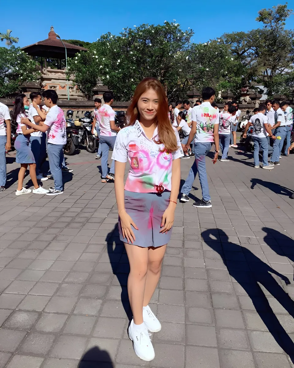Sri Ayu Tarisa in spray-painted shirt stands outdoors with group