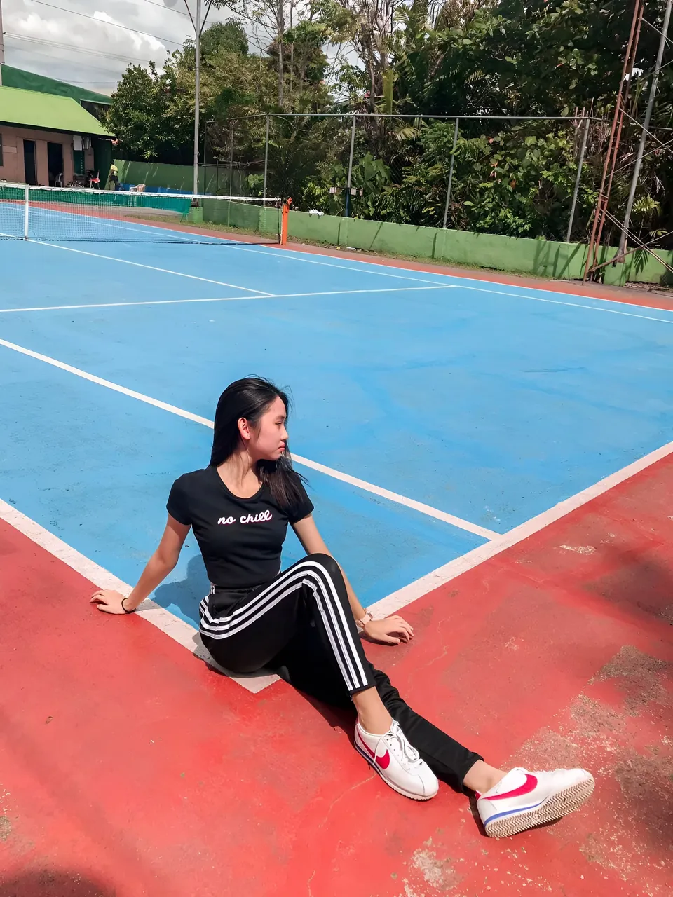 Stephanie Jean King sitting on red tennis court with blue playing surface