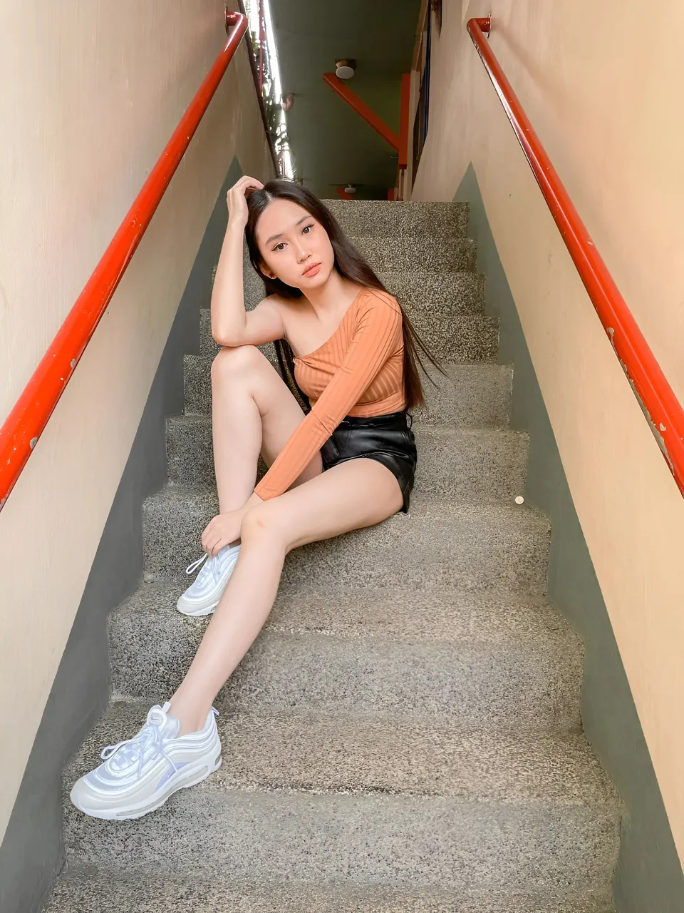 Stephanie Jean King sitting on concrete stairs with red railings