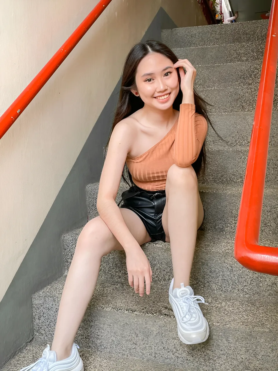 Stephanie Jean King sitting on concrete stairs with red railings
