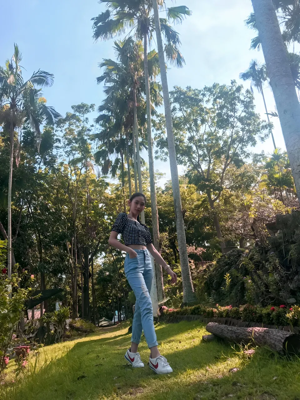 Stephanie Jean King standing on grass with tall palm trees in background