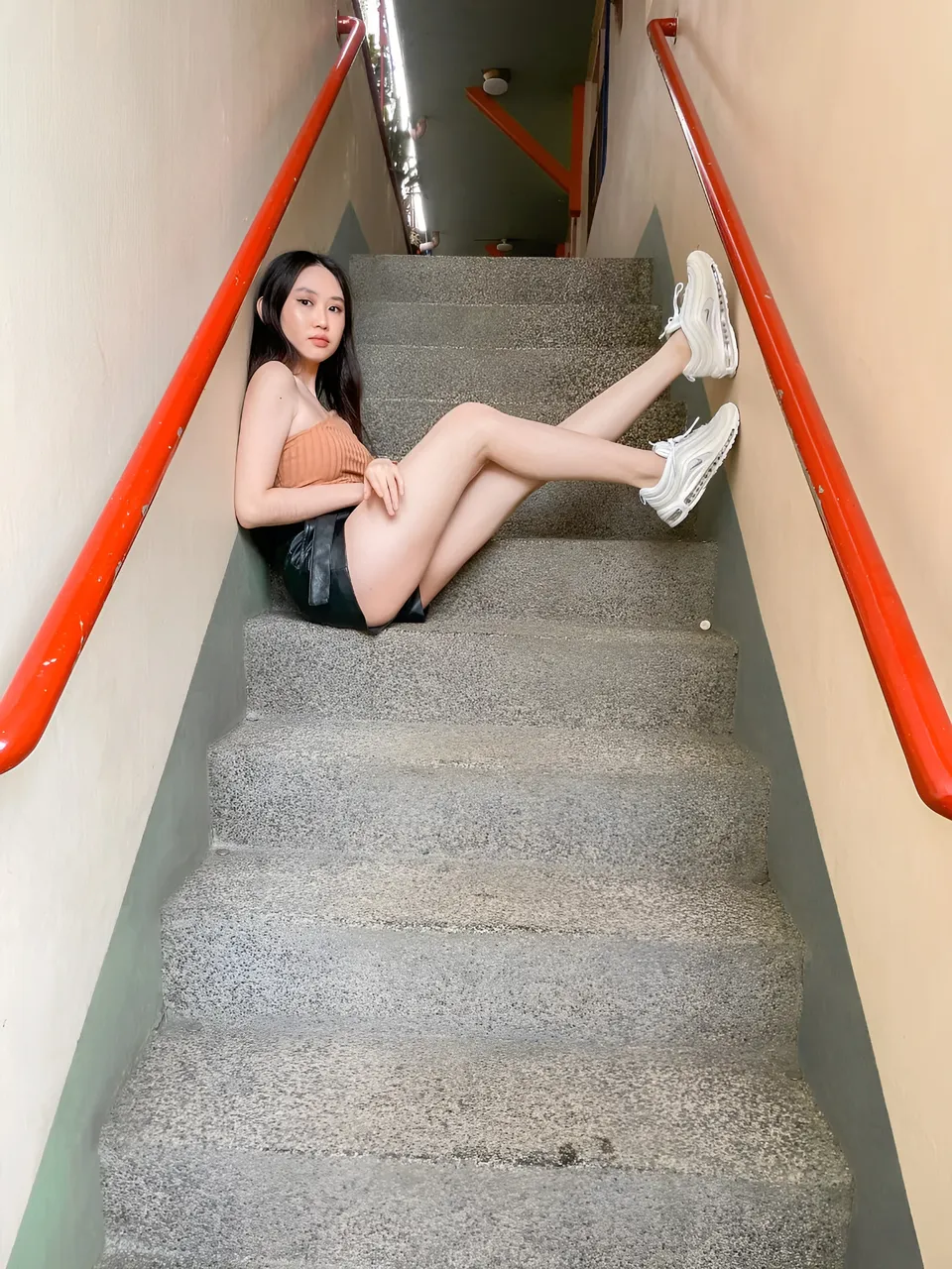 Stephanie Jean King seated on concrete stairs with red handrails