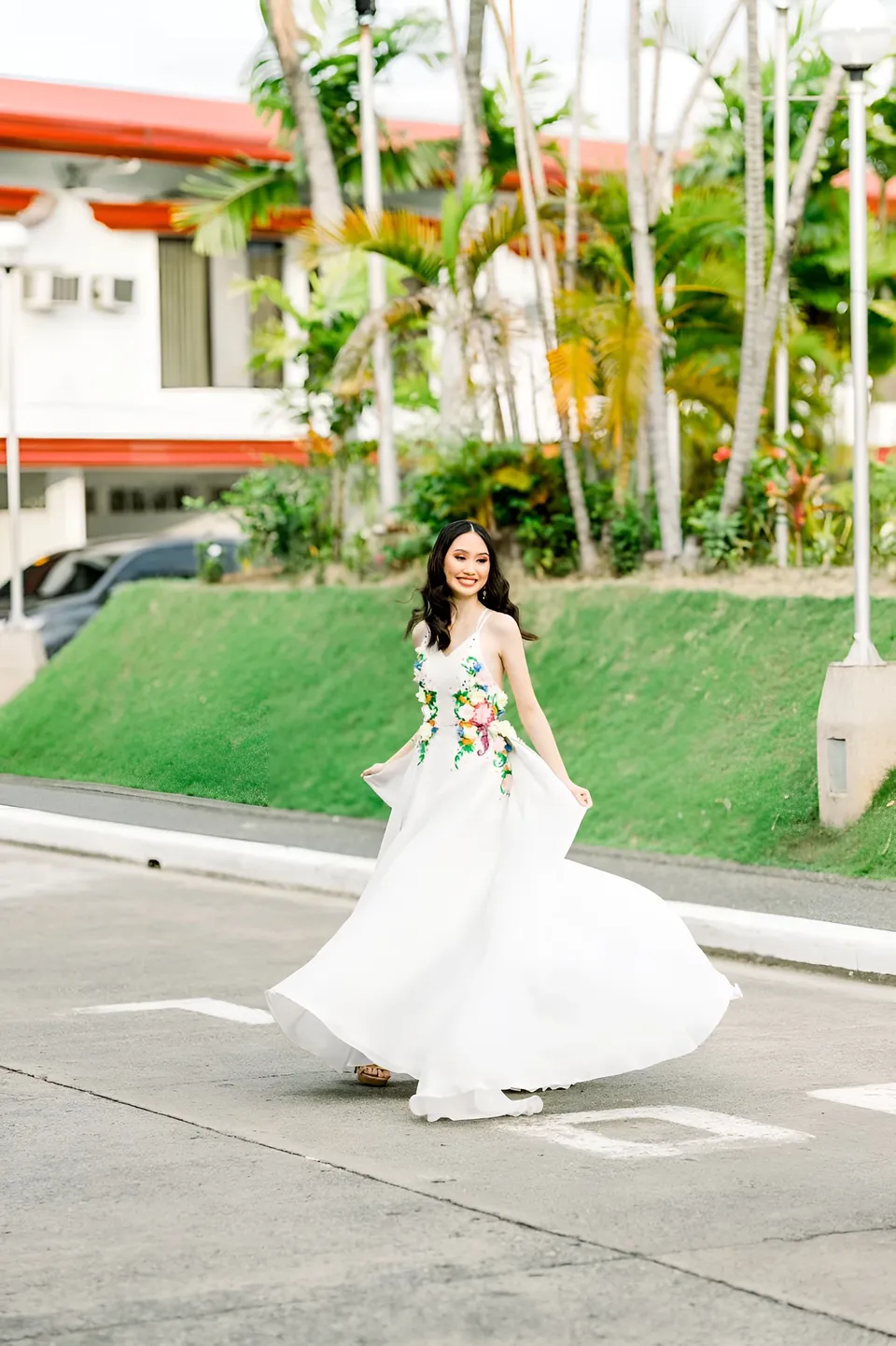 Stephanie Jean King in white floral gown walking on paved street