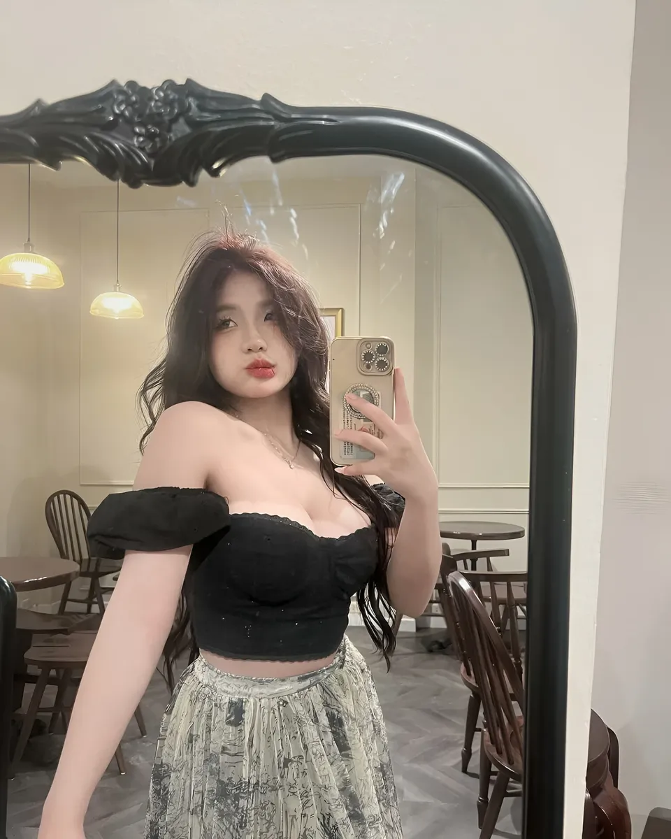 Yue Arden takes mirror selfie wearing black top and patterned skirt