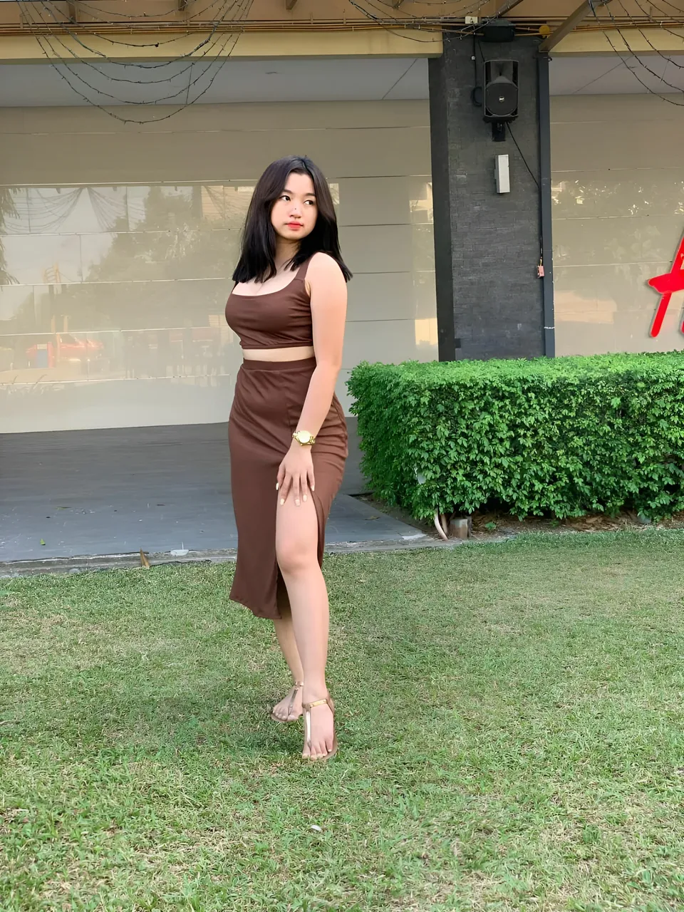 Yumi Mizayaki in brown two-piece outfit standing on grass outdoors