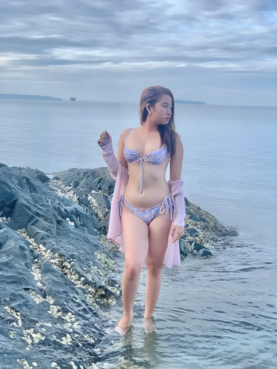 Yumi Mizayaki in patterned bikini and cover-up standing in shallow water