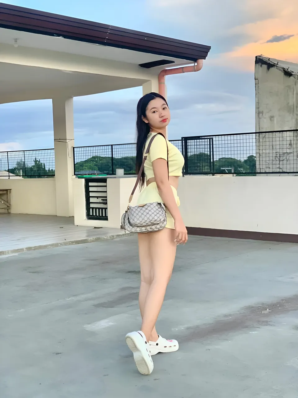 Yumi Mizayaki in yellow top and shorts standing on rooftop
