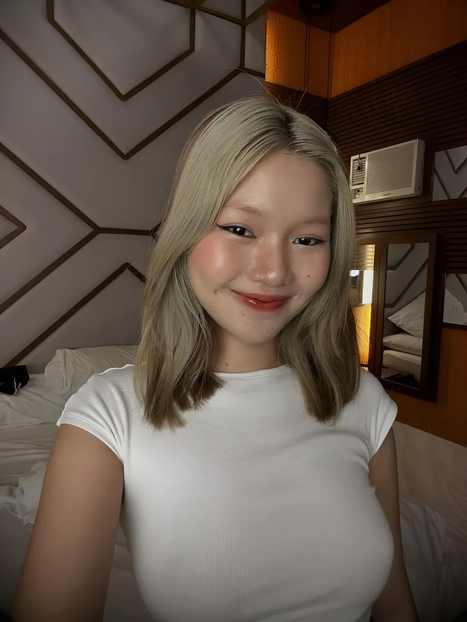 Zandra Hayes in white top smiling in room with geometric wall design
