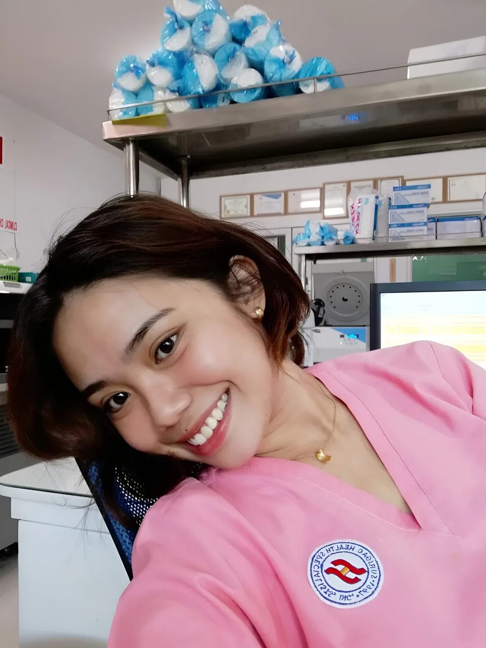 Zianne Tremedal in pink top smiling at camera in medical office