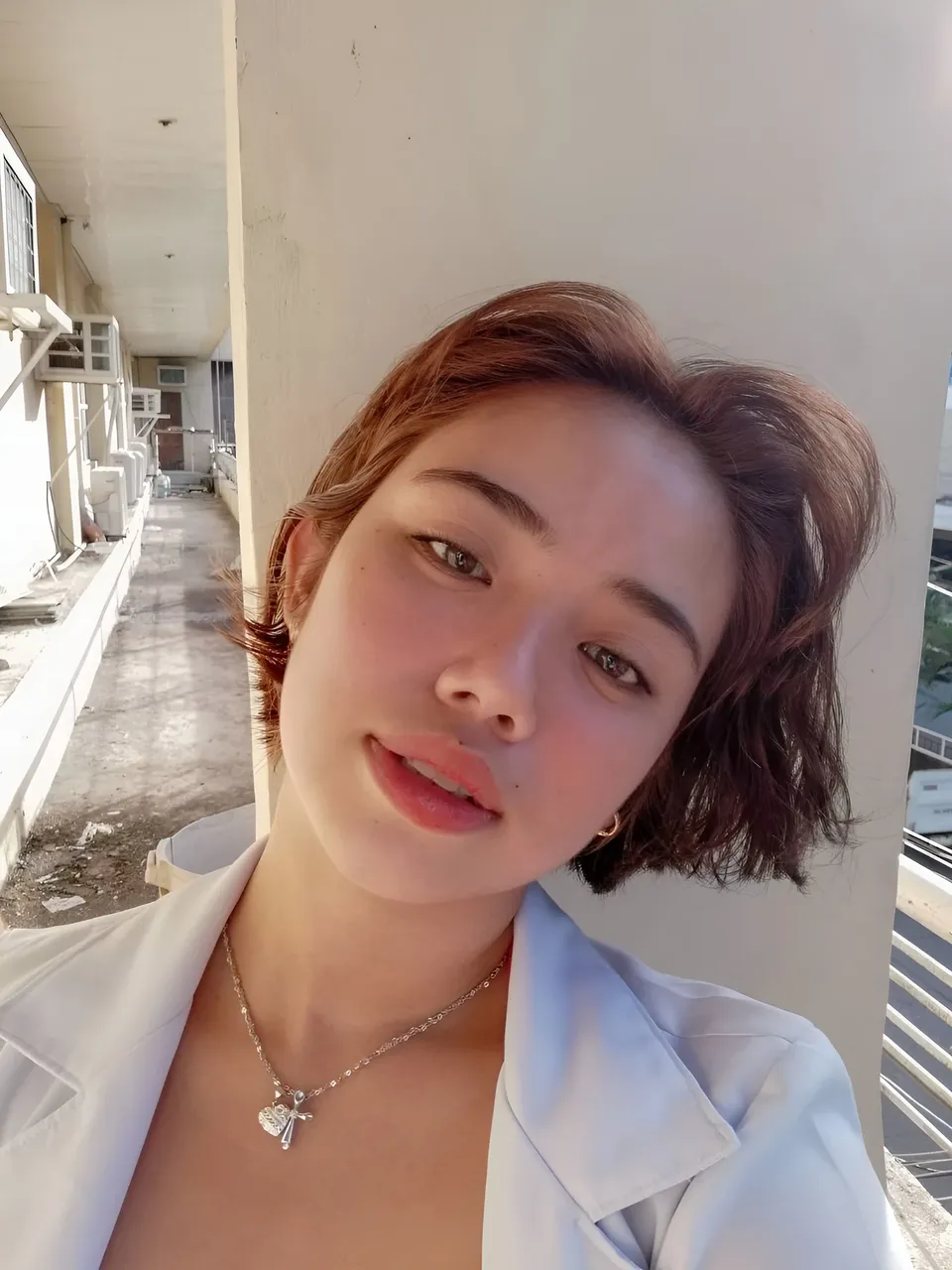 Zianne Tremedal in white coat taking selfie outdoors